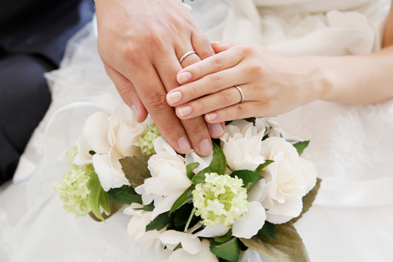 結婚指輪を着けたカップルの手元