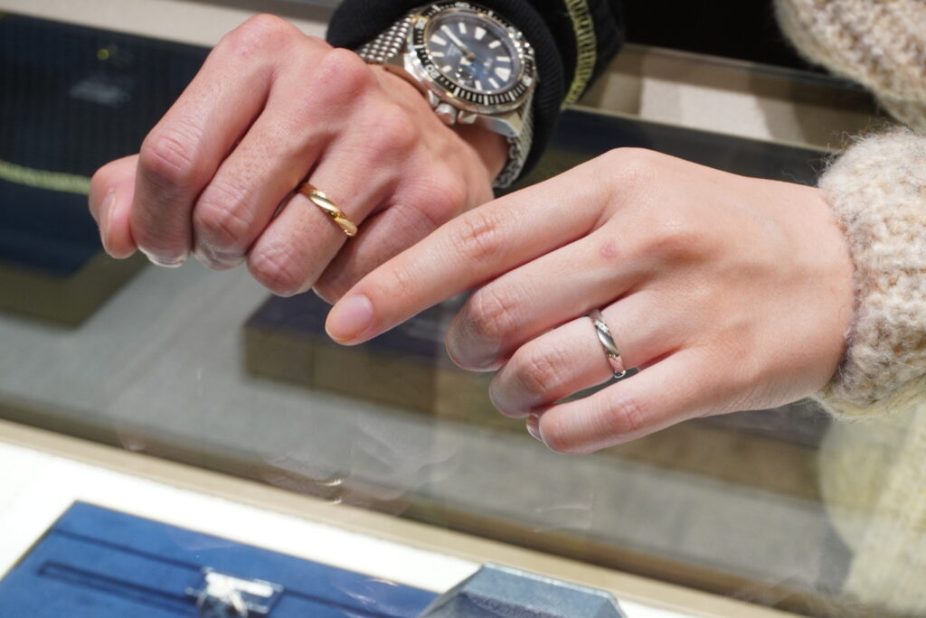 ロイヤル・アッシャーの結婚指輪を着けたカップルの手元