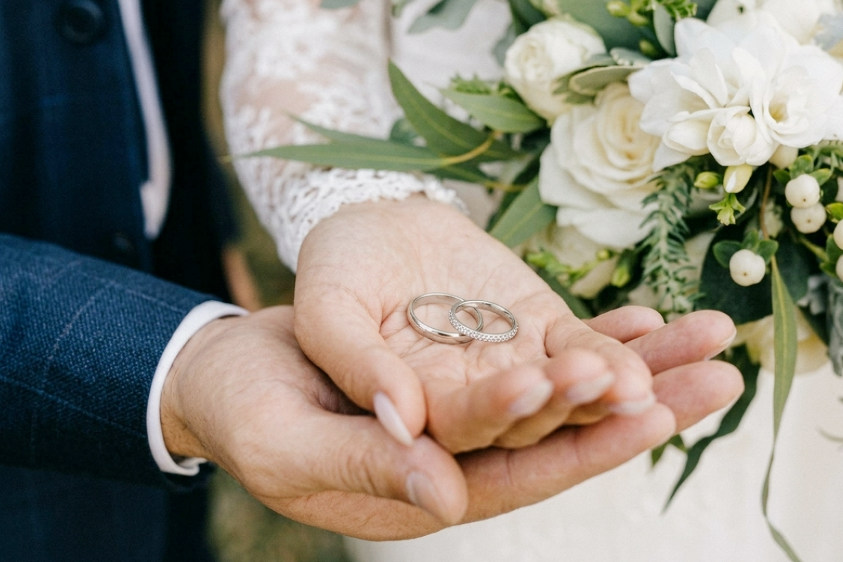 結婚指輪を乗せたカップルの手