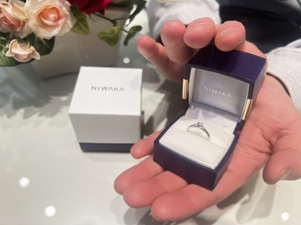 NIWAKA(ニワカ)の婚約指輪の入ったケースを持つ男性