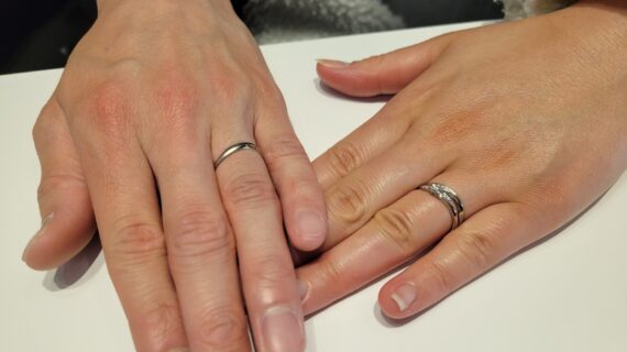 アンティックの婚約指輪とシンデレラの結婚指輪を着けたカップルの手元