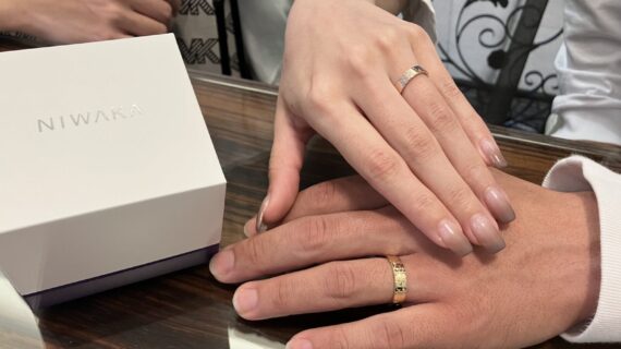 NIWAKAの花匠の彫の結婚指輪をつけるカップル