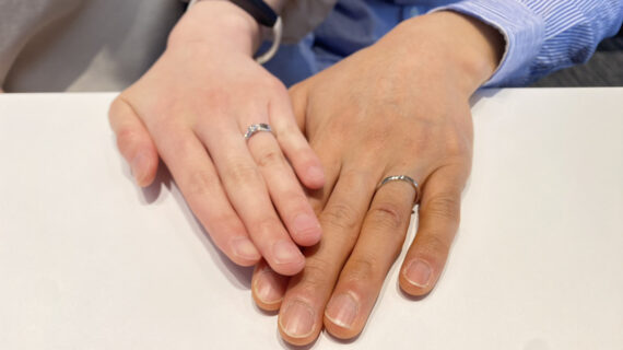 俄の婚約指輪と結婚指輪をつけているカップル