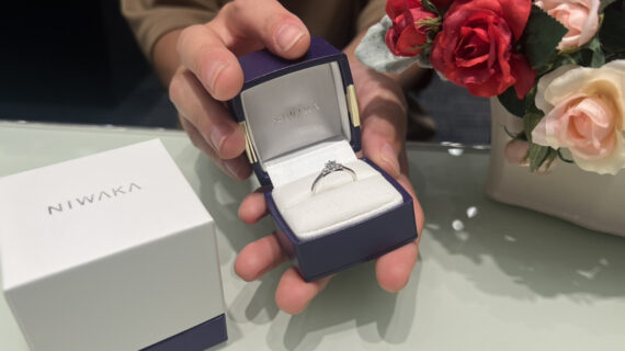 NIWAKAの婚約指輪が入ったケースを持つ男性