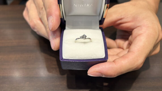 NIWAKAの婚約指輪が入った箱を持つ男性