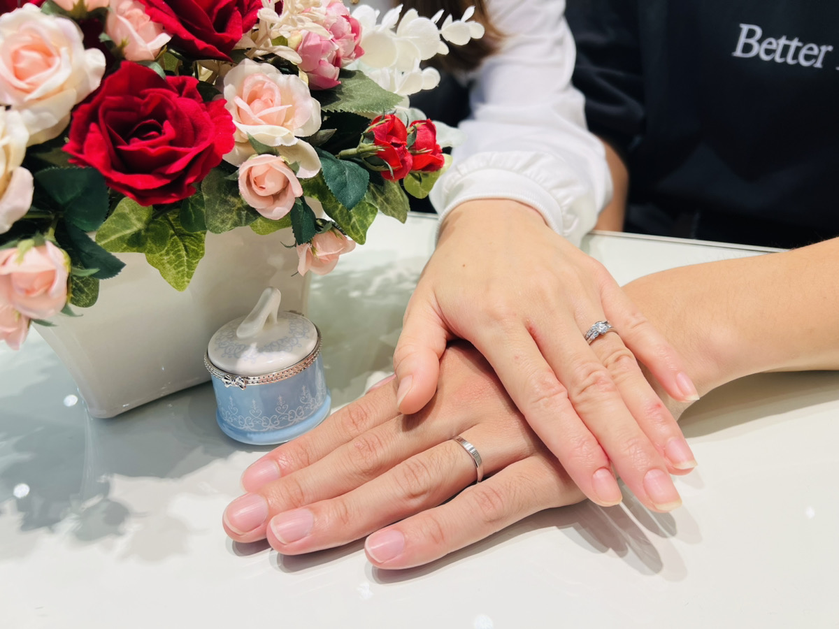 シンデレラの婚約指輪と結婚指輪を着けたカップルの手元