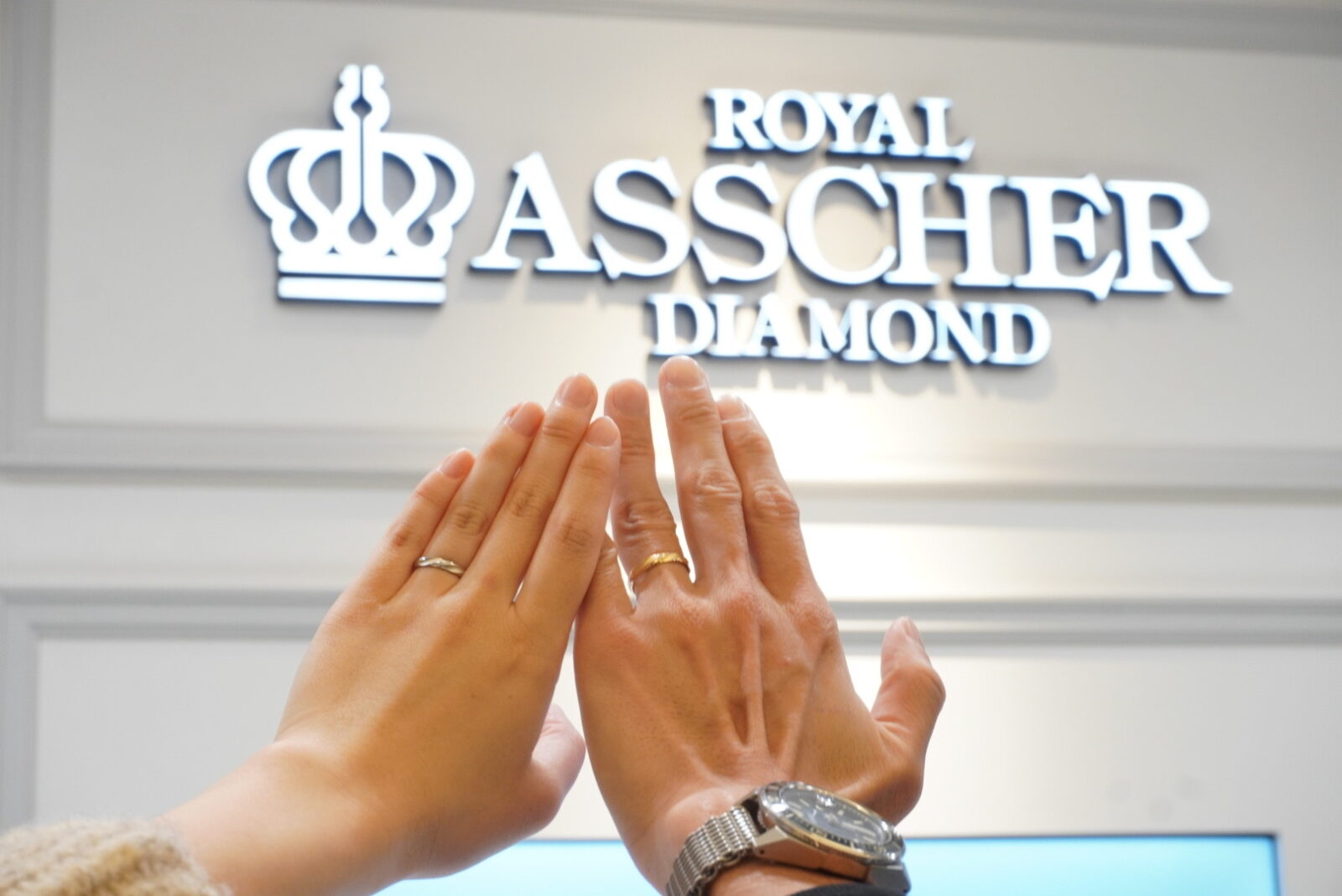 ロイヤル・アッシャーの結婚指輪を着けたカップルの手元