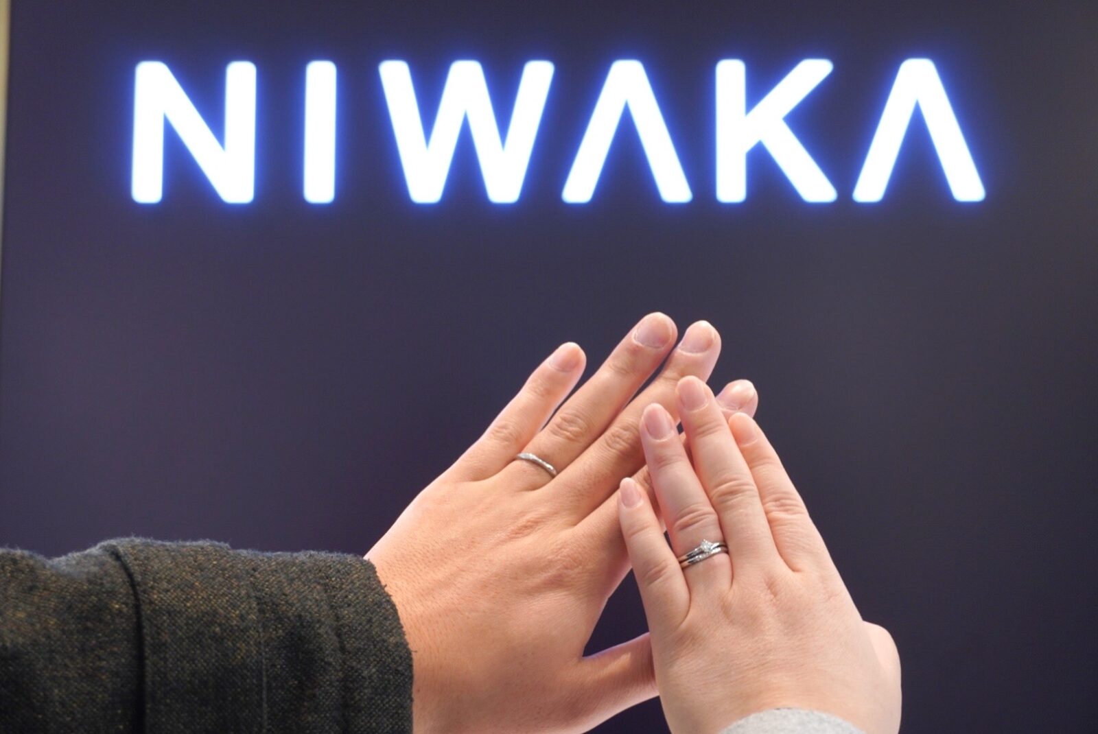 NIWAKA（ニワカ）の婚約指輪と結婚指輪を着けたカップルの手元