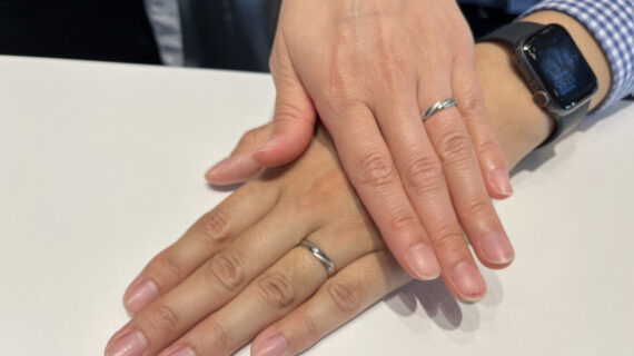 ロイヤル・アッシャーの結婚指輪を着けたカップルの手