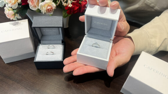 カフェリングの婚約指輪の入ったケースを持つ男性と結婚指輪の入ったケース