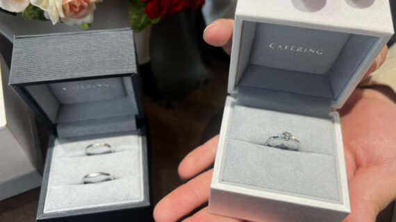 カフェリングの婚約指輪の入ったケースを持つ男性と結婚指輪の入ったケース