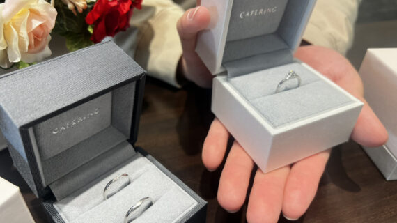 カフェリングの婚約指輪の入ったケースを持つ男性と結婚指輪の入ったケース