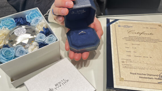 ロイヤルアッシャーの婚約指輪が入ったケースを持つ男性