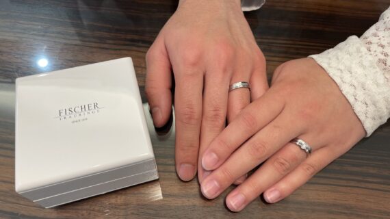 フィッシャーの結婚指輪をつけているカップルの写真