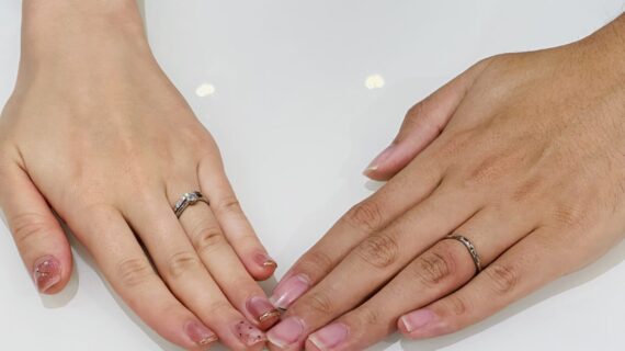 ロイヤル・アッシャーの婚約指輪と結婚指輪を着けたカップルの手元