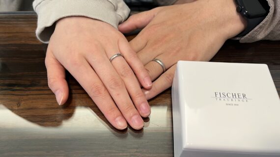 フィッシャーの結婚指輪を着けているカップルの手元