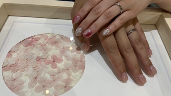 ラザールダイヤモンドとカフェリングの結婚指輪を身に付けているカップルの手元