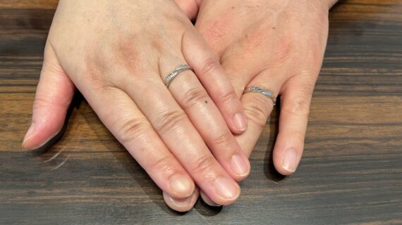 ロイヤル・アッシャーの結婚指輪を身に着けているカップルの手元