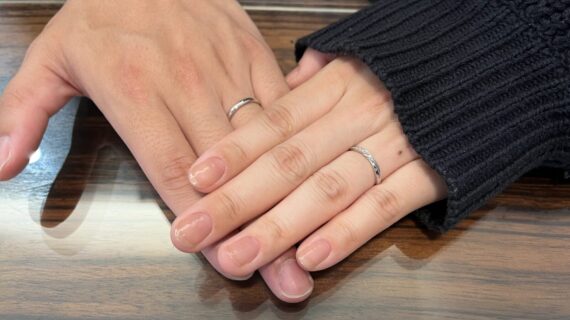 ニワカとルシエの結婚指輪を身に着けているカップルの手元