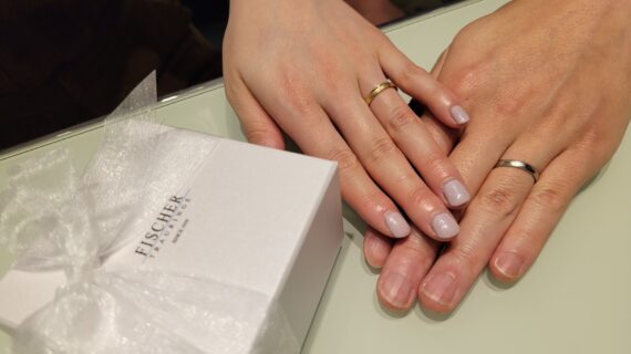 フィッシャーの結婚指輪を着けたカップルの手元