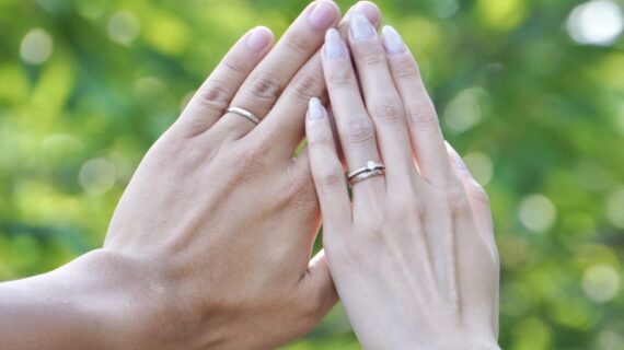婚約指輪と結婚指輪を着けたカップルの手元