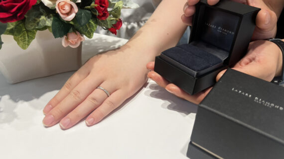 ラザールダイヤモンドの結婚指輪を着けた女性とケースを持つ男性