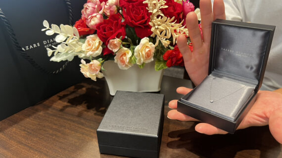ラザールダイヤモンドの婚約ネックレスが入ったケースを持つ男性