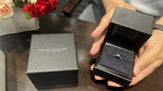 ラザールダイヤモンドの婚約指輪が入ったケースを持つ男性