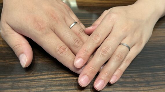ノクルの結婚指輪を身につけるカップルの手元