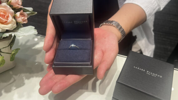 ラザールダイヤモンドの婚約指輪が入ったケースを持つ男性