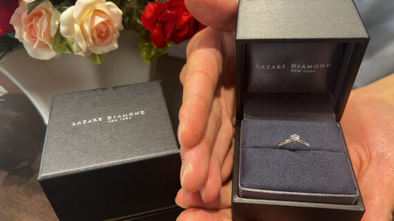 ラザールダイヤモンドの婚約指輪が入ったケースを持つ男性