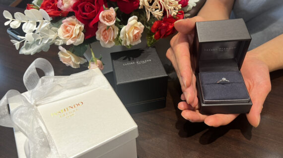 ラザールダイヤモンドの婚約指輪が入ったケースを持つ男性