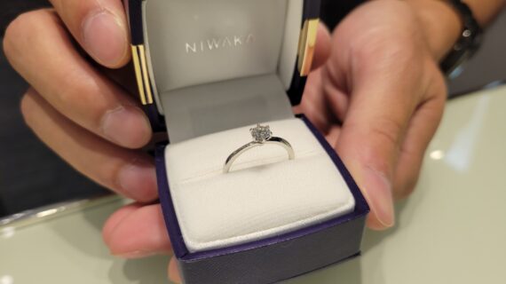 NIWAKA（ニワカ）の婚約指輪を持つ男性の手元