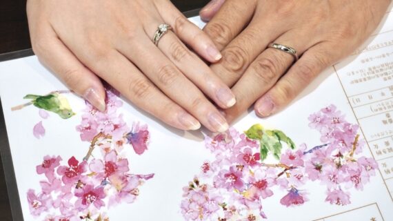 NIWAKA（ニワカ）の婚約指輪と結婚指輪を着けたカップルの手元