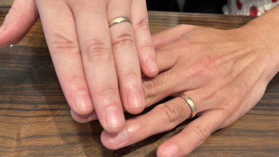 フィッシャーの結婚指輪を身に付けるカップルの手元