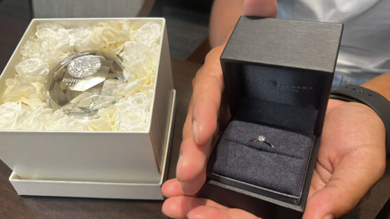 ラザールダイヤモンドの婚約指輪が入ったケースを持つ男性の手元