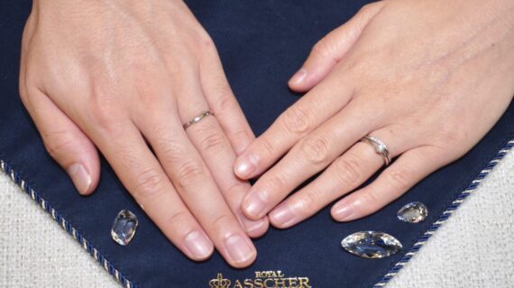 ロイヤル・アッシャーの婚約指輪と結婚指輪を着けたカップルの手元