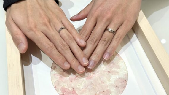 ラザールダイヤモンドの婚約指輪と結婚指輪を着けたカップルの手元