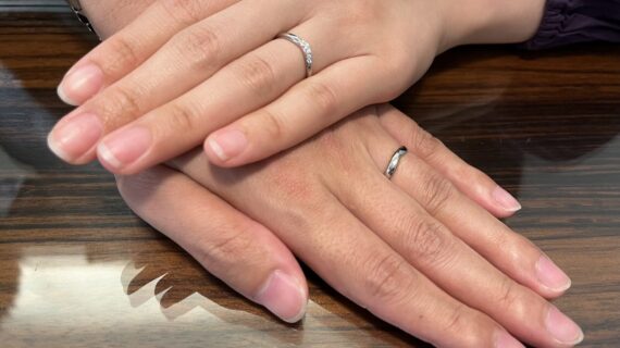 ラザールダイヤモンドの結婚指輪を身に付けるカップルの手元