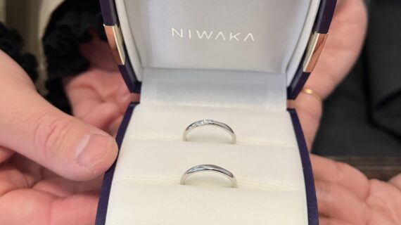 ニワカの結婚指輪が入っているケースを持つカップル