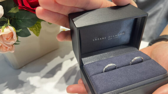ラザールダイヤモンドの結婚指輪が入ったケースを持つ男性の手元