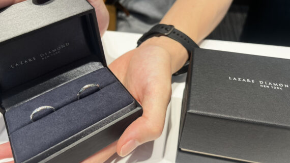 ラザールダイヤモンドの結婚指輪が入ったケースを持つ男性の手元