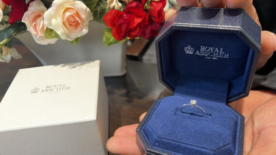 ロイヤル・アッシャーの婚約指輪が入ったケースを持つ男性の手元
