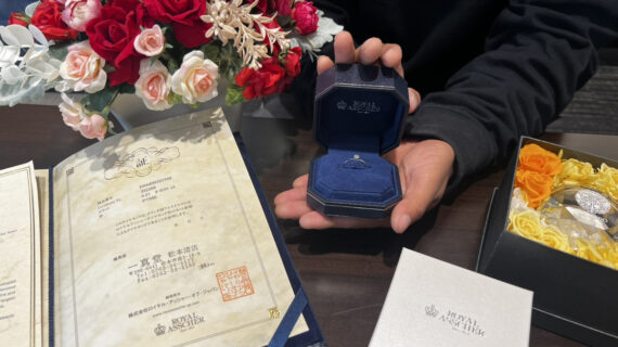 ロイヤル・アッシャーの婚約指輪が入ったケースを持つ男性の手元