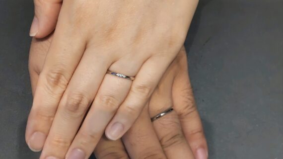 サムシングブルーの結婚指輪を着けたカップル