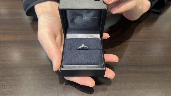 ラザールダイヤモンドの婚約指輪のケースを持つ男性