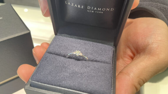 ラザールダイヤモンドの婚約指輪を持つ男性の手元