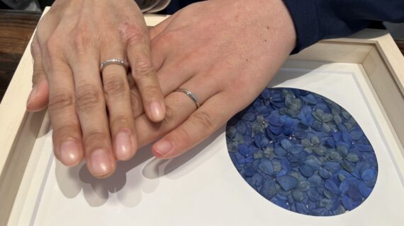 ロイヤルアッシャーの結婚指輪を身に付けるカップルの手元