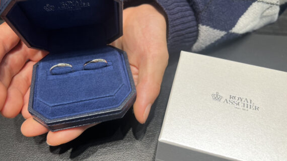 ロイヤル・アッシャーの結婚指輪が入ったケースを持つ男性の手元