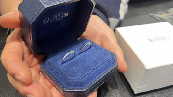 ロイヤル・アッシャーの結婚指輪が入ったケースを持つ男性の手元